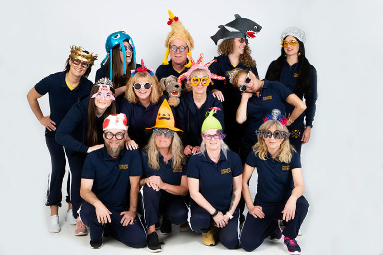 Team mit lustigen Hüten und Mützen