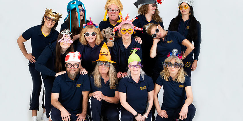 Team mit lustigen Hüten und Mützen